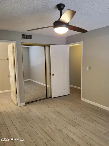 an empty room with wooden floor cabinet and door