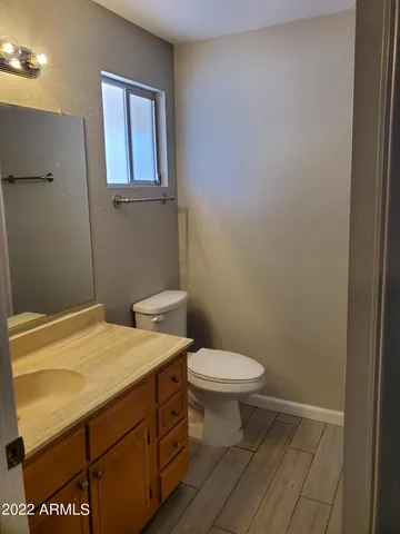 a bathroom with a sink a toilet and a window