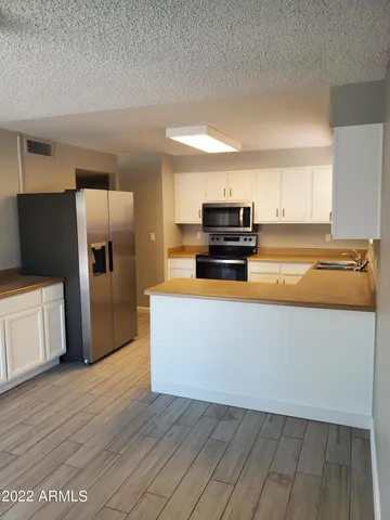 a kitchen with wooden cabinets and stainless steel appliances