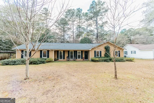 a front view of a house with a yard covered in snow