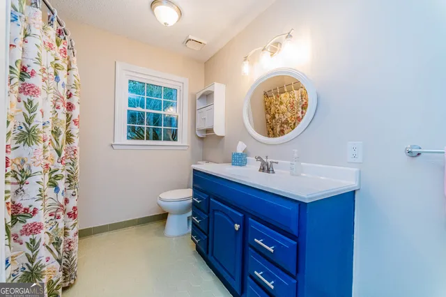 a bathroom with a toilet a sink and a mirror