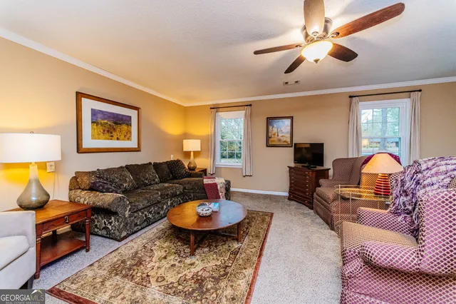 a living room with furniture a rug and a chandelier