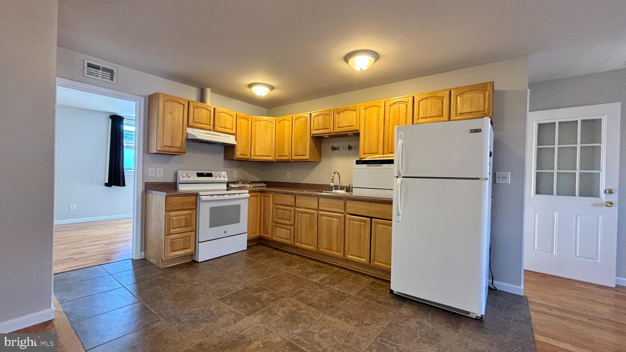 1925 South Bancroft Street Philadelphia, PA 19145 - Photo 5 of 12 a kitchen with white cabinets and stainless steel appliances