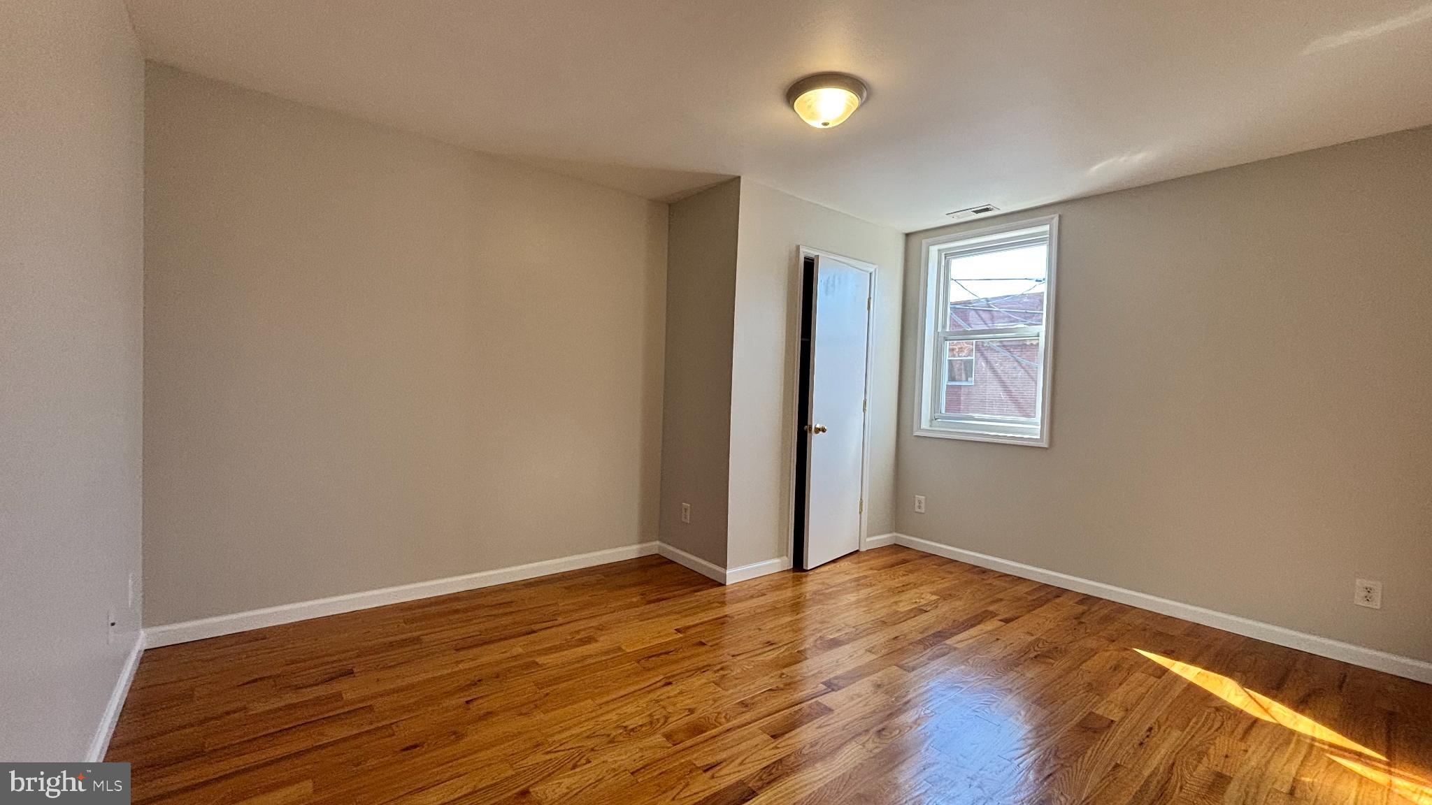 1925 South Bancroft Street Philadelphia, PA 19145 - Photo 8 of 12 an empty room with wooden floor and windows