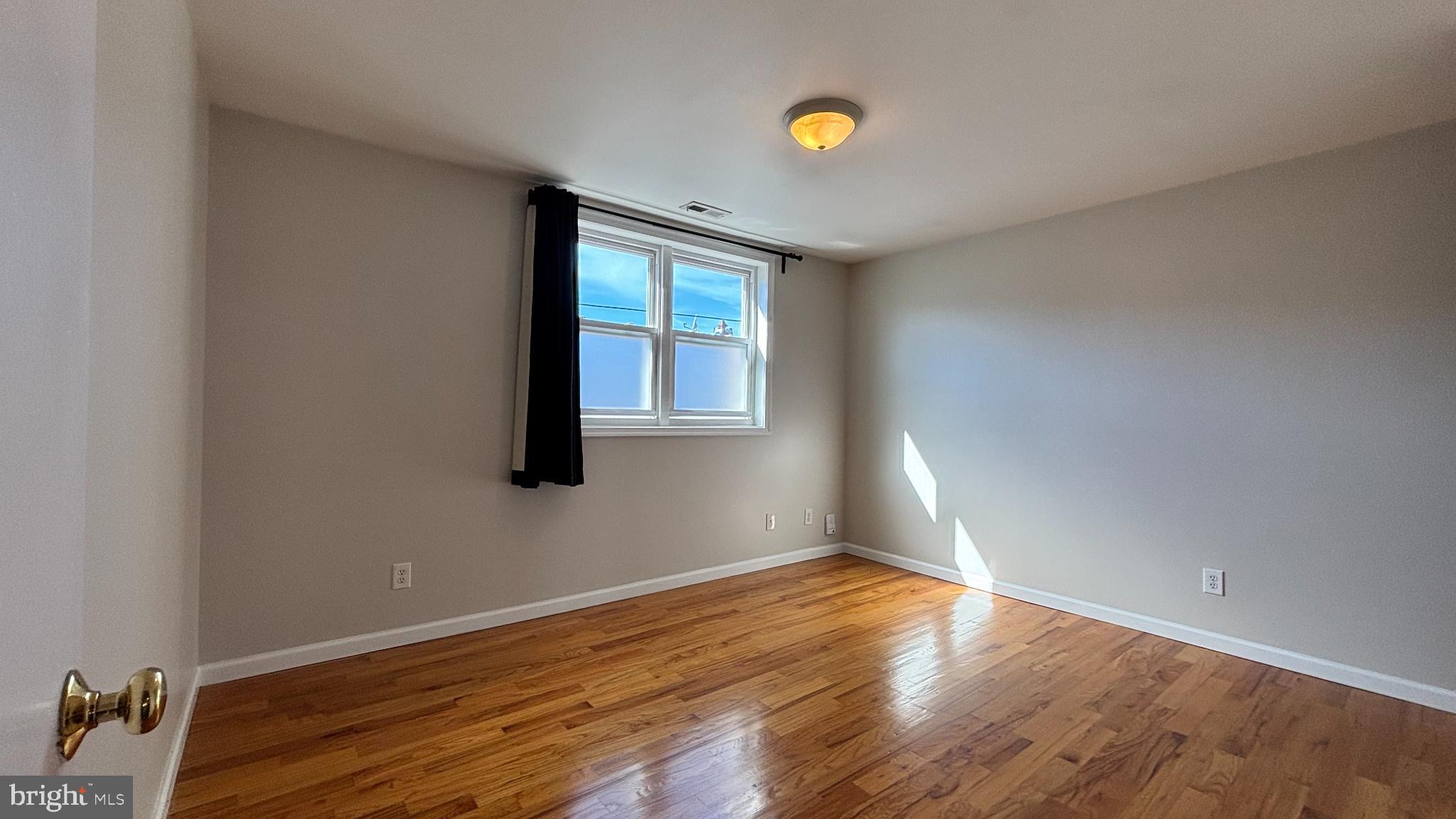 1925 South Bancroft Street Philadelphia, PA 19145 - Photo 9 of 12 an empty room with wooden floor and windows