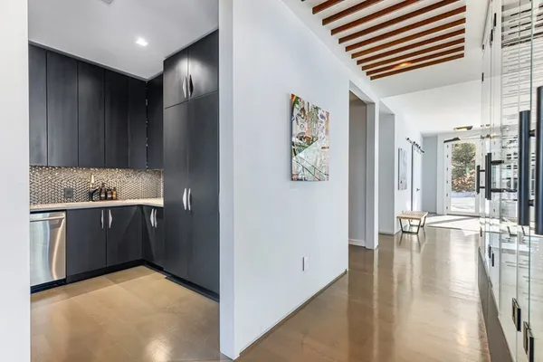 a living room with furniture kitchen view and a large window