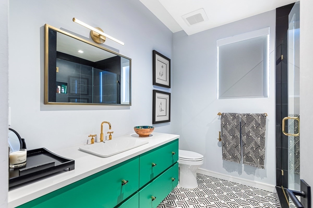 85 Forbes Road Milton, MA 02186 - Photo 18 of 39 a bathroom with a toilet sink and mirror