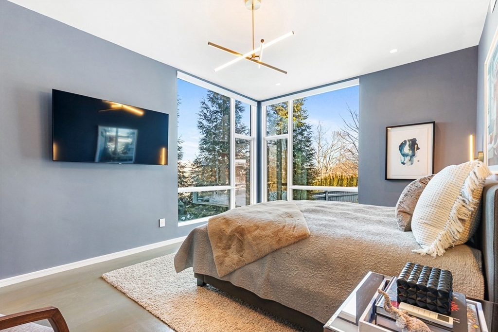 85 Forbes Road Milton, MA 02186 - Photo 19 of 39 a living room with a bed furniture and a flat tv screen