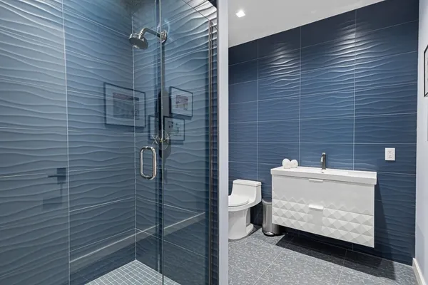 a bathroom with a tub shower sink and mirror