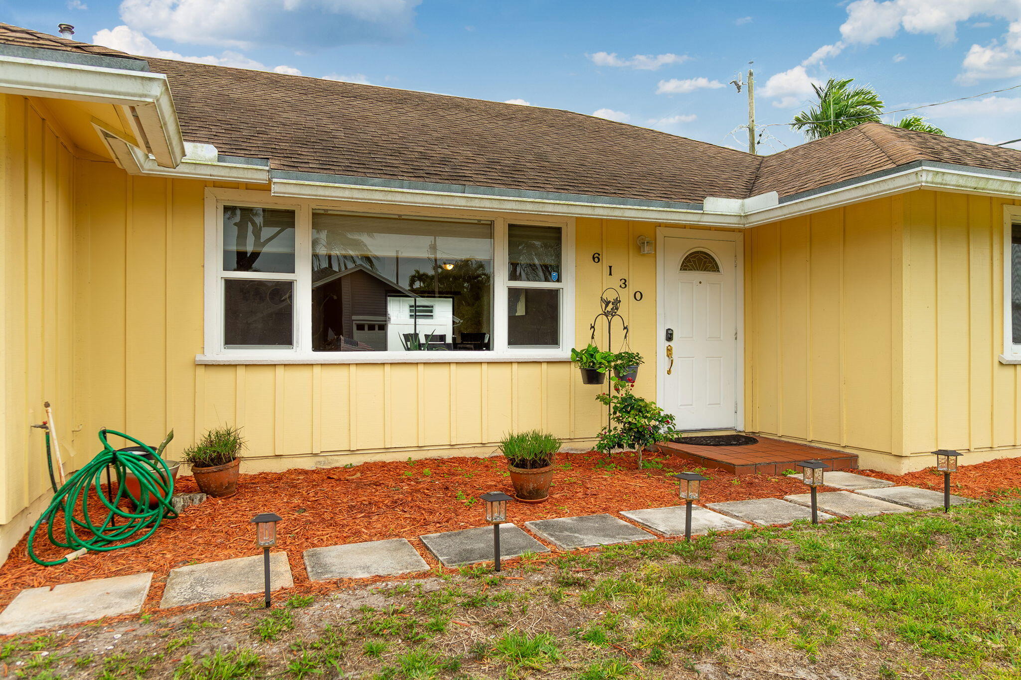 6130 Francis Street Jupiter, FL 33458 - Photo 4 of 27 a front view of a house with a yard