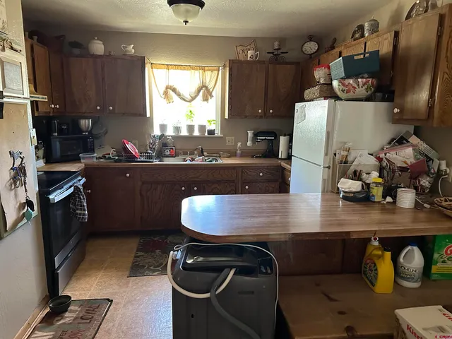 a kitchen with kitchen island a counter space a sink a stove and refrigerator