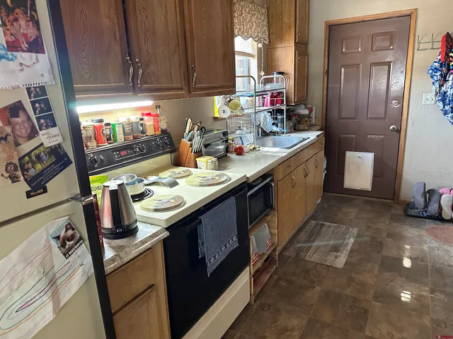 a kitchen with kitchen island granite countertop a sink stove and cabinets