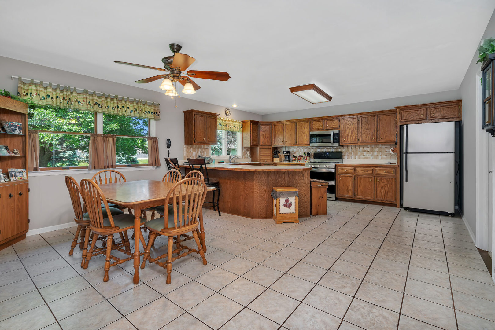 101 San Carlos Road Minooka, IL 60447 - Photo 4 of 15 a kitchen with stainless steel appliances granite countertop a stove a sink a dining table and chairs