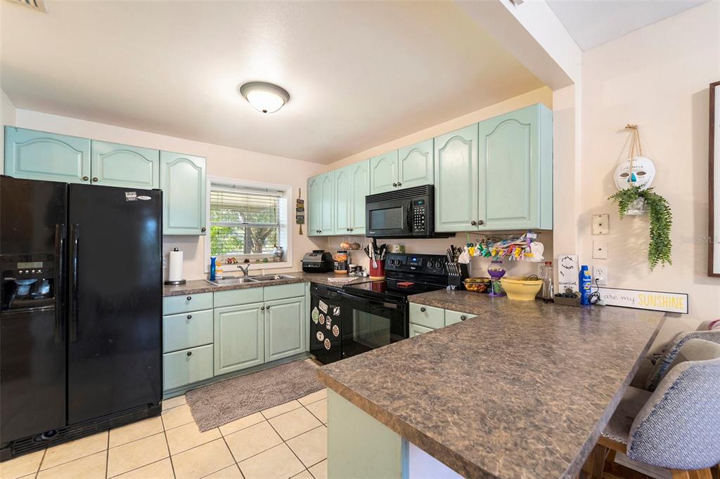 2215 Wallace Road Lutz, FL 33549 - Photo 9 of 15 a kitchen with a sink refrigerator and cabinets