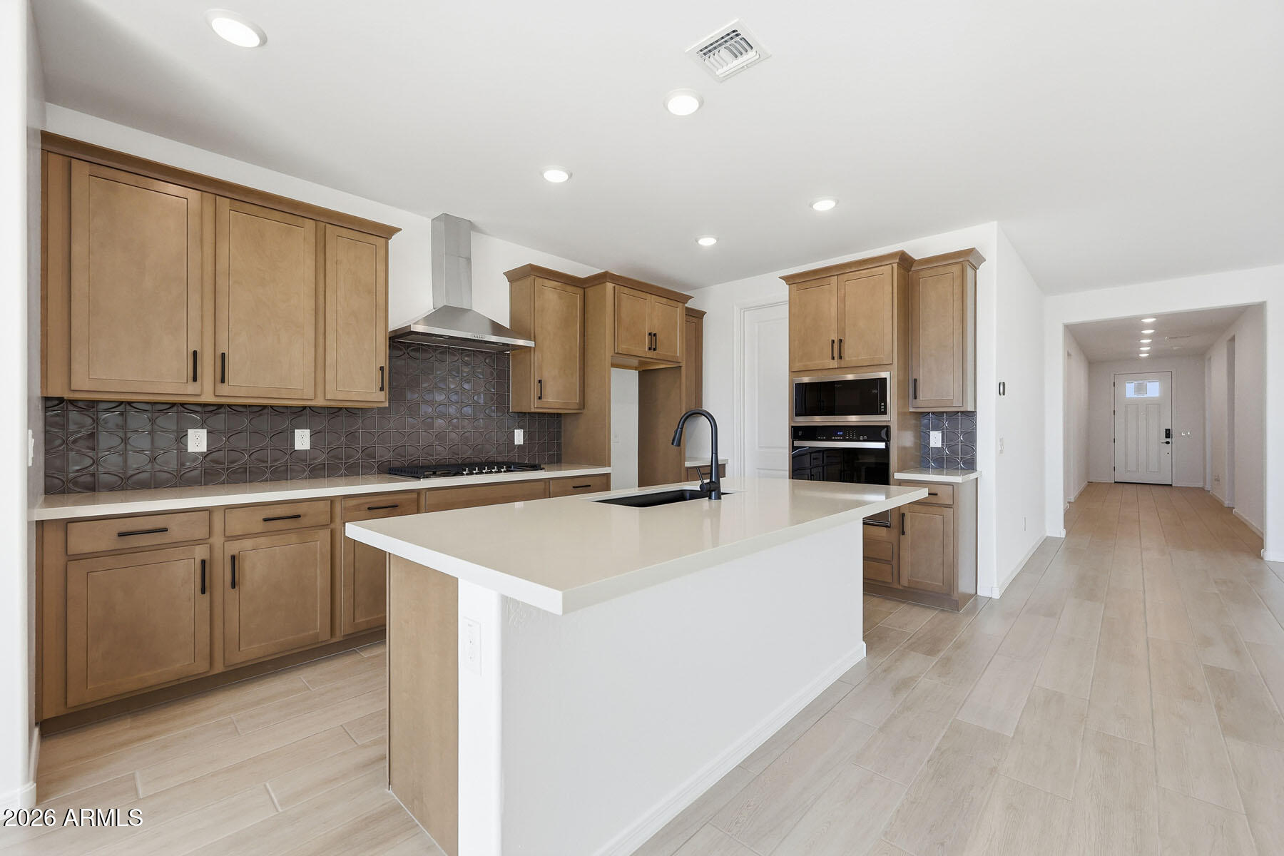 705 West Riparian Drive San Tan Valley, AZ 85140 - Photo 8 of 25 a large kitchen with stainless steel appliances granite countertop a stove a sink a refrigerator and white cabinets with wooden floor