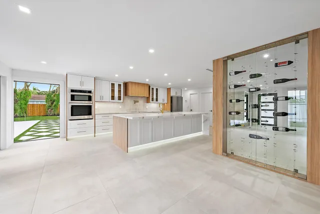 a large white kitchen with a large window