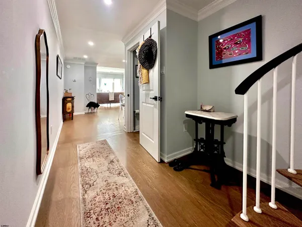 a view of a hallway with wooden floor and furniture
