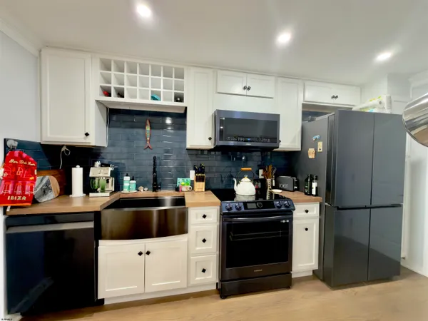 a kitchen with stainless steel appliances a stove refrigerator sink and microwave