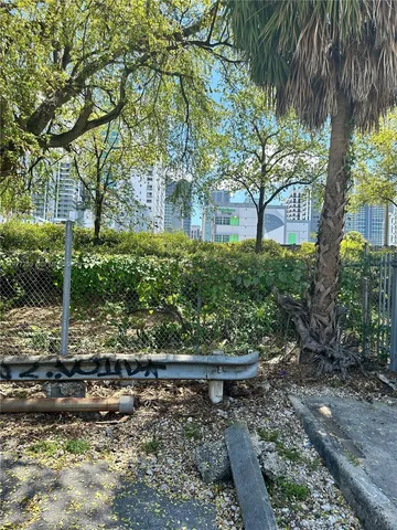 a city view from a balcony with chairs and iron gate
