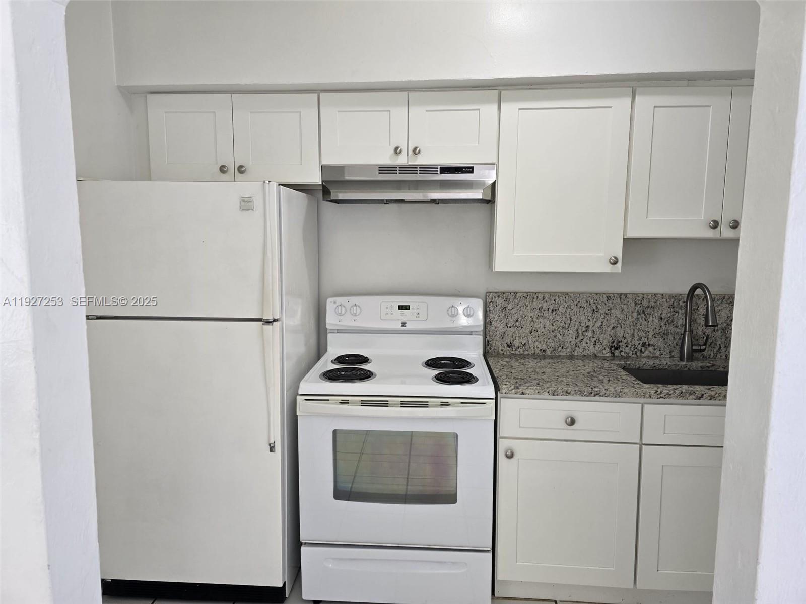 364 Southwest 11th Street Miami, FL 33130 - Photo 26 of 61 a kitchen with a stove a refrigerator and a white cabinets