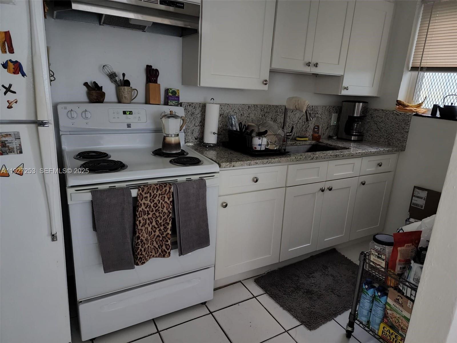 364 Southwest 11th Street Miami, FL 33130 - Photo 44 of 61 a kitchen with a stove a microwave and cabinets