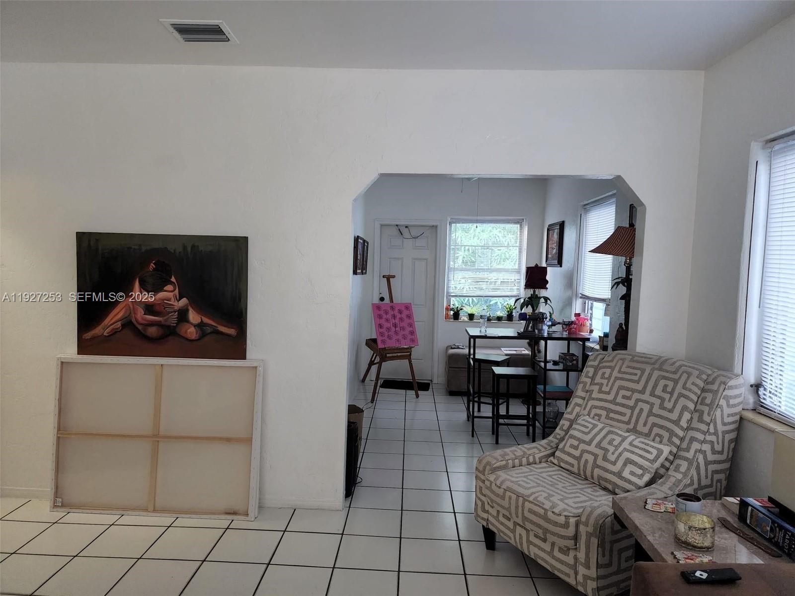 364 Southwest 11th Street Miami, FL 33130 - Photo 52 of 61 a living room with furniture a dining table and a painting on the wall