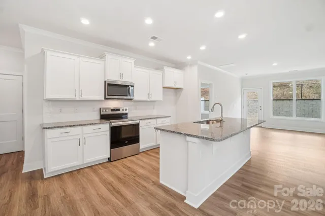 a kitchen with granite countertop a stove and a sink