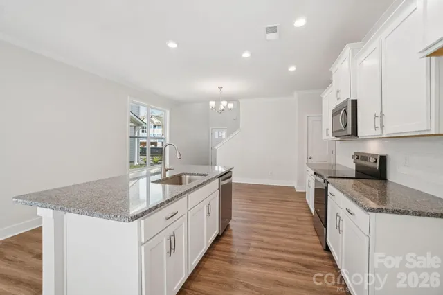 a kitchen with granite countertop a sink and cabinets