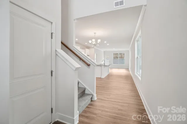 a view of a hallway with wooden floor and staircase