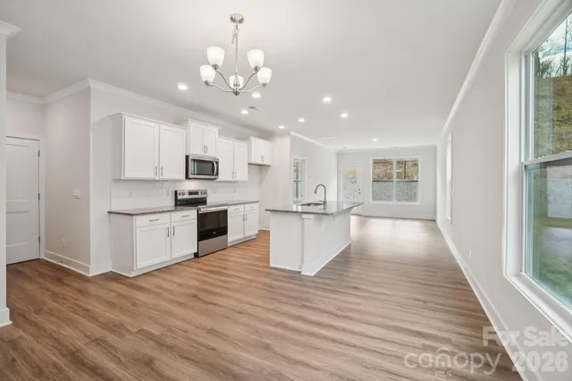 a view of kitchen with sink microwave refrigerator and cabinets