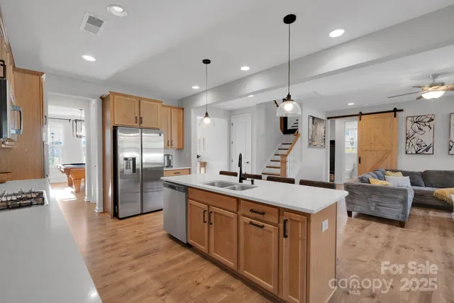 a kitchen with stainless steel appliances granite countertop a sink a stove and a refrigerator