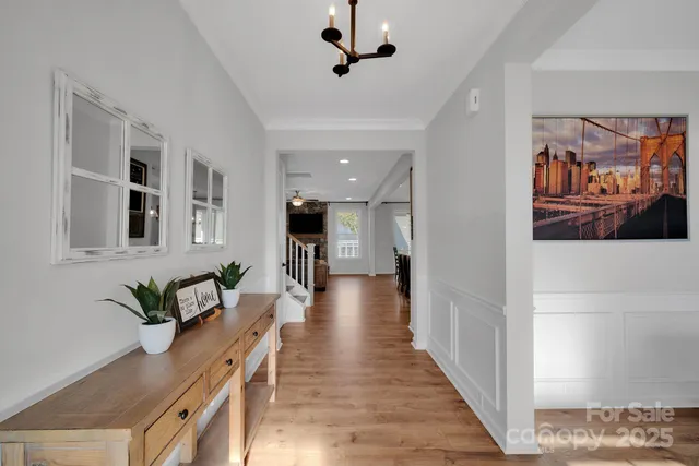 a view of a hallway with wooden floor and furniture