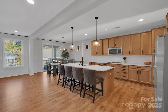 a large kitchen with lots of counter space dining table and stainless steel appliances