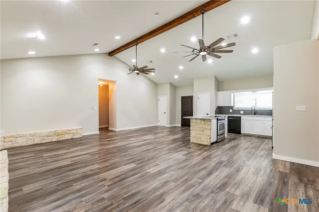 a kitchen with granite countertop stainless steel appliances a stove a sink and a microwave