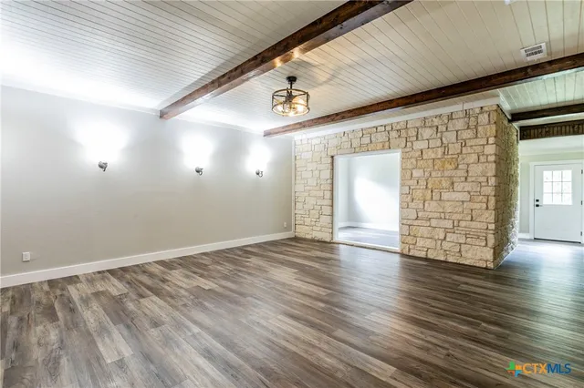 an empty room with wooden floor and window