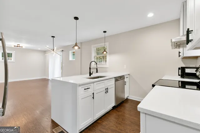 a kitchen with sink cabinets and wooden floor