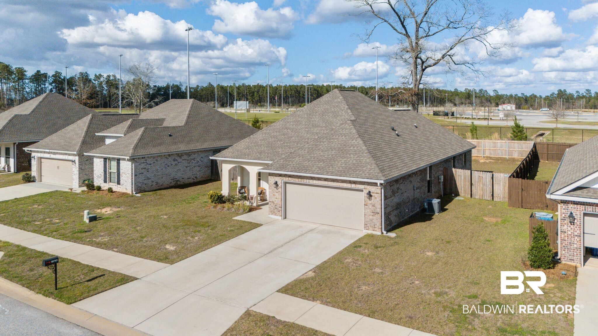 10745 Brodick Loop Daphne, AL 36527 - Photo 2 of 39 View of front of property with a shingled roof, an attached garage, brick siding, and concrete driveway