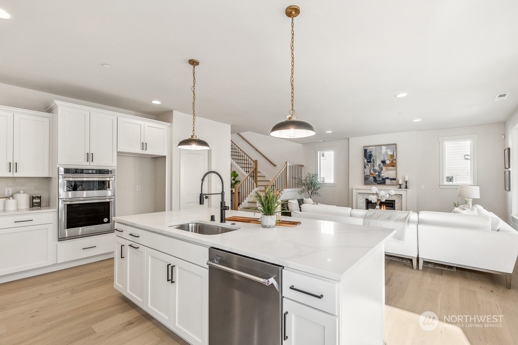 23337 13th (lot 5) Avenue Southeast Bothell, WA 98021 - Photo 3 of 27 a kitchen with stainless steel appliances kitchen island granite countertop a sink a stove and cabinets