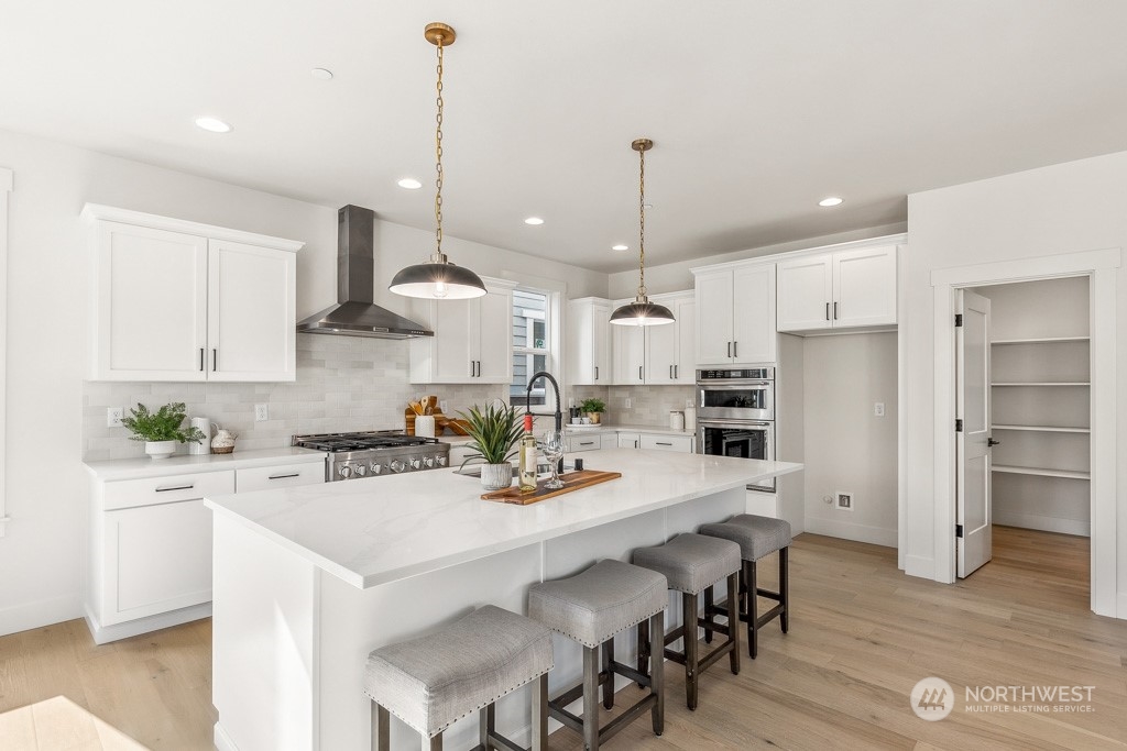 23337 13th (lot 5) Avenue Southeast Bothell, WA 98021 - Photo 7 of 27 a kitchen with a dining table chairs stainless steel appliances and cabinets