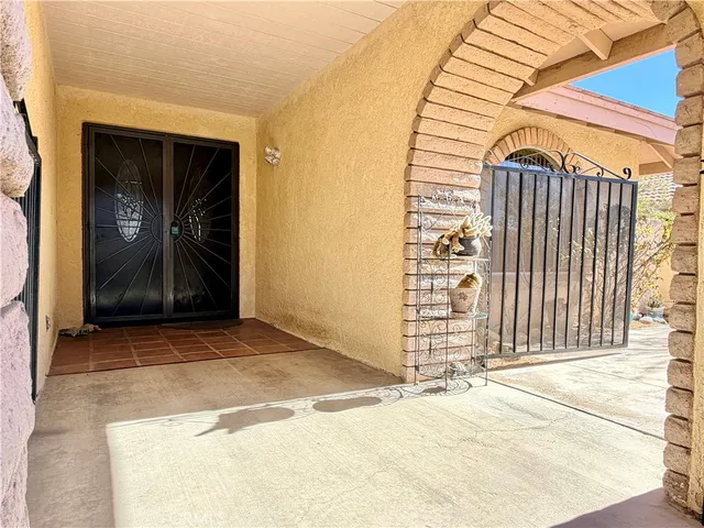 a view of a hallway to a livingroom with wooden floor and a window