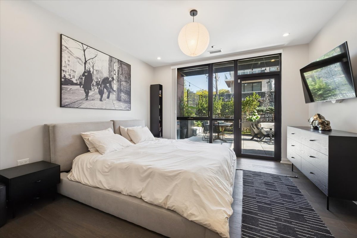 1648 West Division Street, Unit 208 Chicago, IL 60622 - Photo 26 of 48 a spacious bedroom with a large bed and a large window