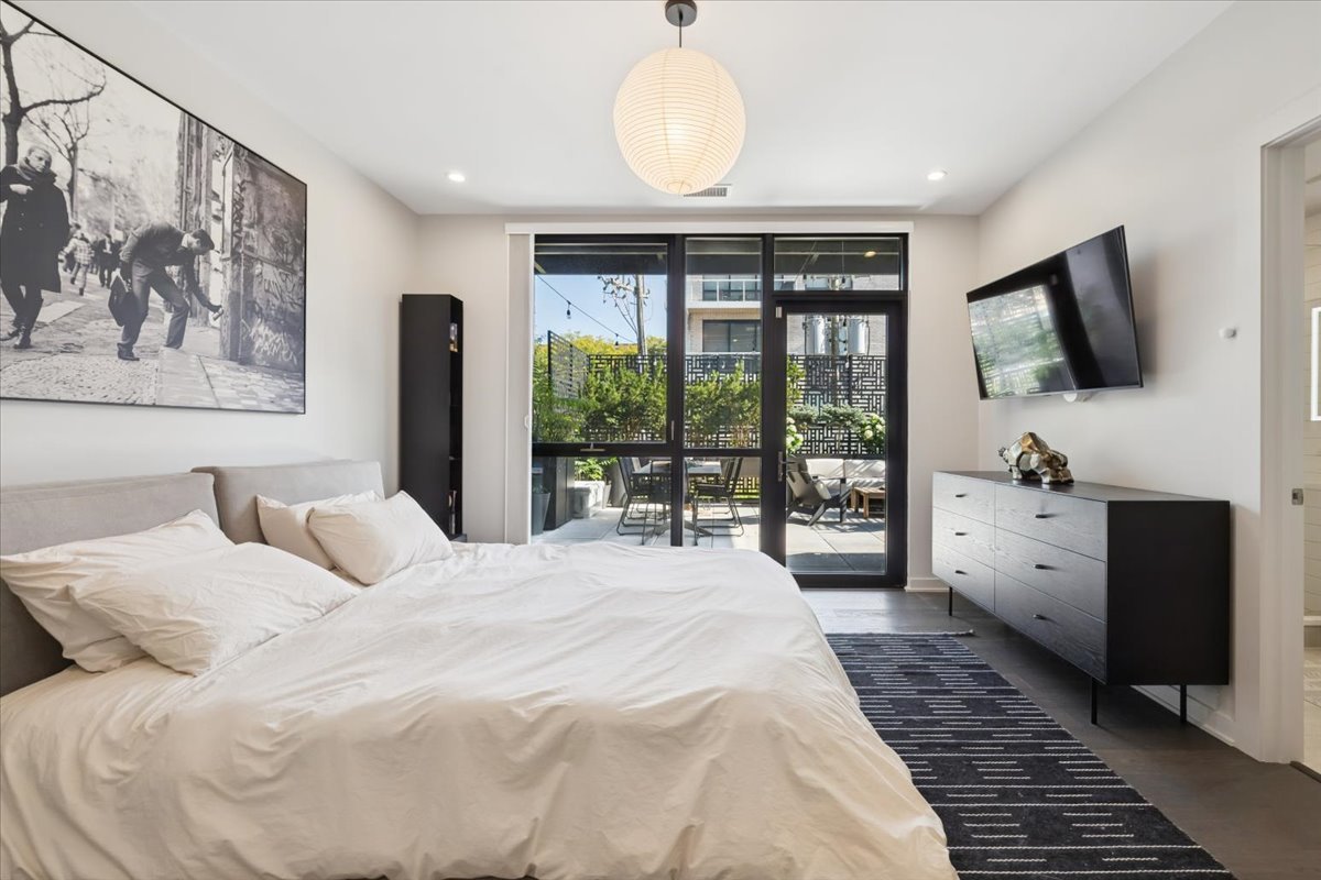 1648 West Division Street, Unit 208 Chicago, IL 60622 - Photo 27 of 48 a bedroom with a large bed and a flat tv screen on the dresser