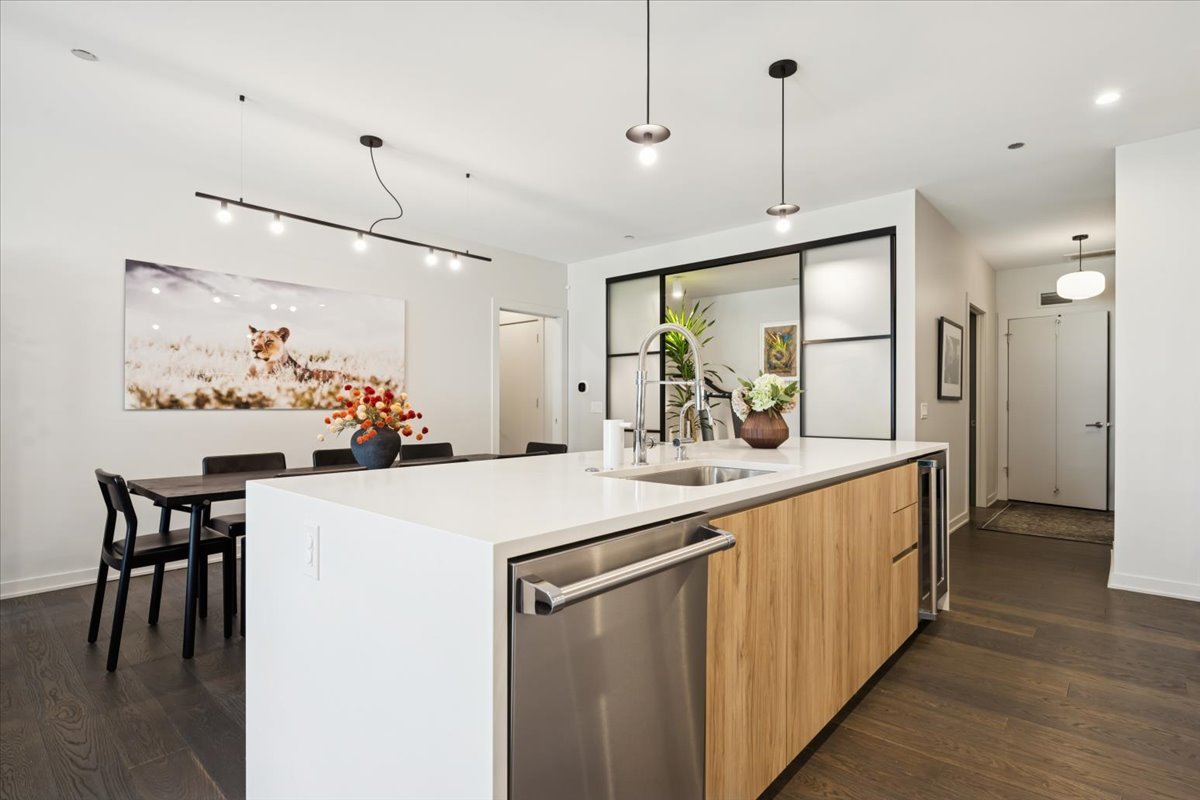 1648 West Division Street, Unit 208 Chicago, IL 60622 - Photo 6 of 48 a kitchen with stainless steel appliances kitchen island granite countertop a table chairs and a refrigerator