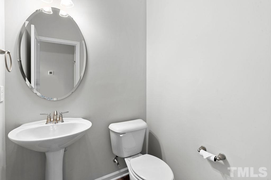 2223 Chattering Lory Lane Apex, NC 27502 - Photo 24 of 49 a bathroom with a toilet sink and mirror