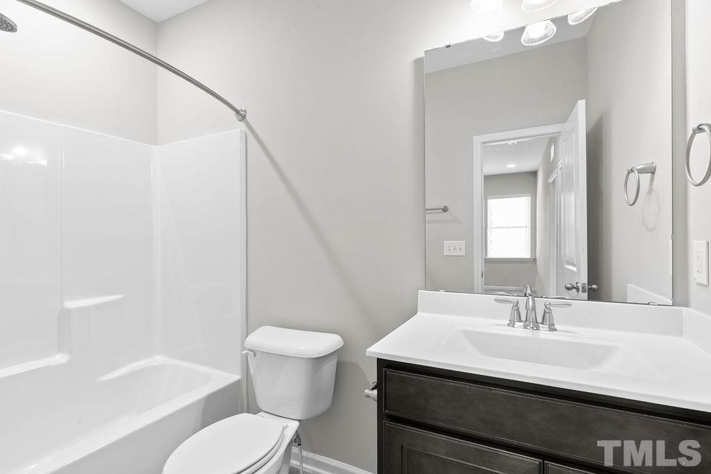 2223 Chattering Lory Lane Apex, NC 27502 - Photo 34 of 49 a bathroom with a sink toilet a mirror and shower