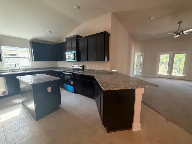 a kitchen with stainless steel appliances granite countertop a sink a stove and a refrigerator