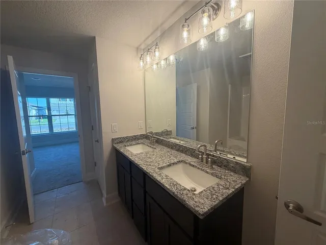 a bathroom with a granite countertop sink and a mirror