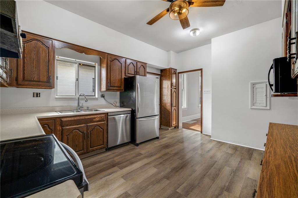 1630 State Avenue Coraopolis, PA 15108 - Photo 18 of 47 a kitchen with stainless steel appliances granite countertop a refrigerator a sink dishwasher a stove with wooden floor and cabinets