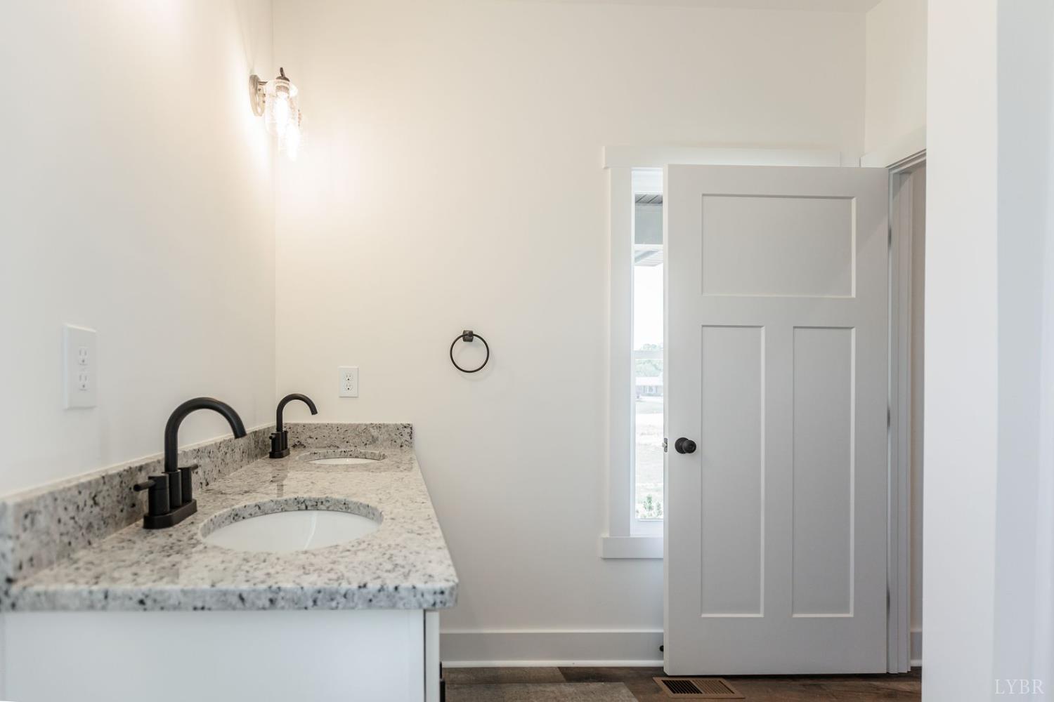 9740 Oakville Road Gladstone, VA 24553 - Photo 47 of 75 a bathroom with a granite countertop sink and a mirror