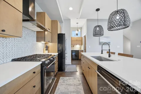 a kitchen with stainless steel appliances granite countertop a sink stove and refrigerator